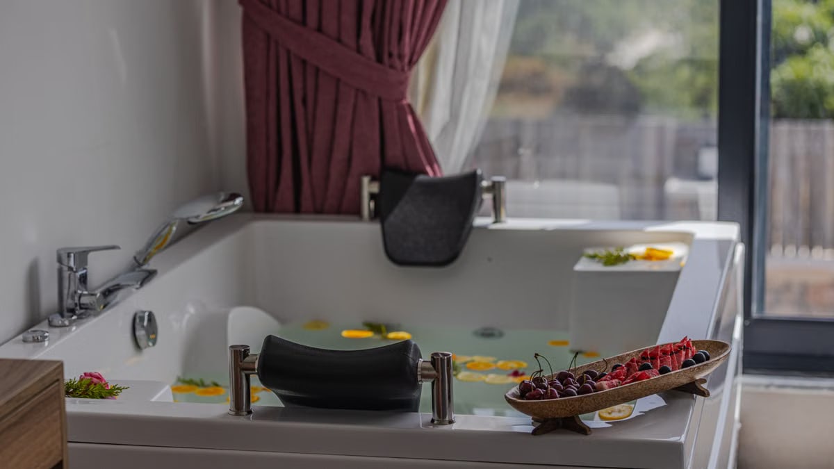 Relaxing indoor bath scene with fruits and petals, perfect for spa or luxury home vibes.